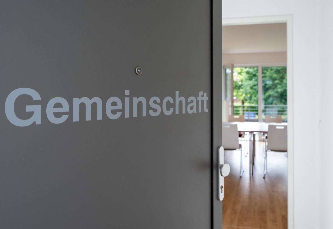 Tür mit der Aufschrift Gemeinschaft, dahinter der Gemeinschaftsraum