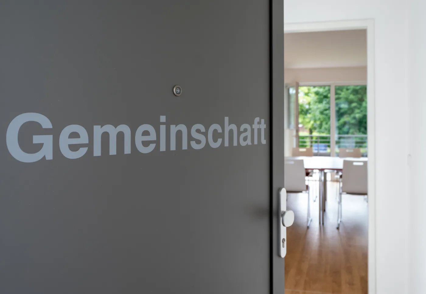Tür mit der Aufschrift Gemeinschaft, dahinter der Gemeinschaftsraum
