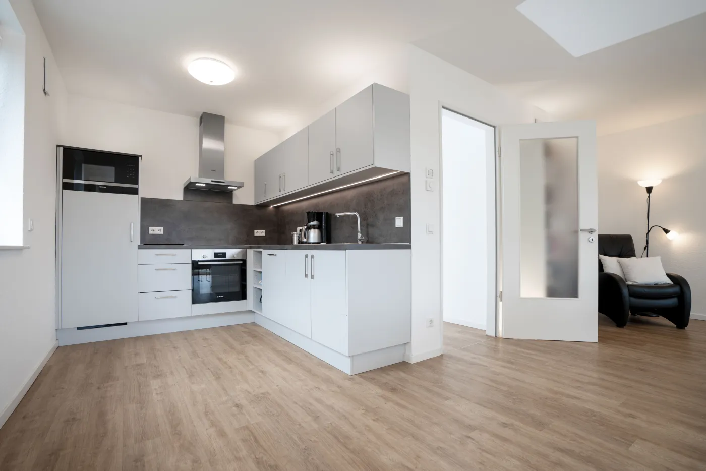 Moderne Einbauküche mit Holzboden in einer Wohnung